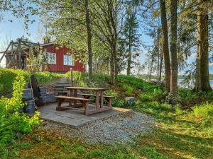 een houten picknicktafel voor een rood huis bij Holiday Home Haukiranta by Interhome in Kittilä