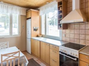 uma cozinha com armários de madeira e um forno com placa de fogão em Holiday Home Ylläskankare by Interhome em Äkäslompolo