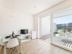 a white apartment with a dining room and a balcony at Apartment Capo Falcone Charming Apartment-2 by Interhome in Villa Sirena