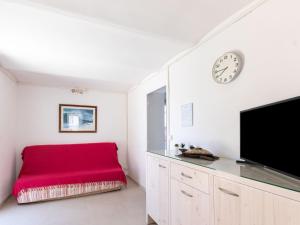 - un salon avec un canapé rouge et un réveil dans l'établissement Apartment Anaisim by Interhome, à Saint-Cyr-sur-Mer