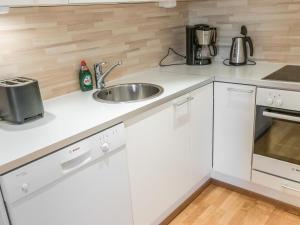 una cucina con mobili bianchi e un lavandino di Holiday Home Ski chalets 7204 by Interhome a Ylläsjärvi