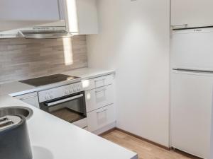 una cucina bianca con piano cottura e frigorifero di Holiday Home Ski chalets 7204 by Interhome a Ylläsjärvi