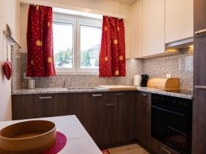 een keuken met rode gordijnen en een raam bij Apartment Chesa Derby 27 by Interhome in St. Moritz