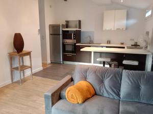 Una sala de estar con un sofá y una cocina. en Beau T2 sur le vieux port, centre de Bastia, en Bastia
