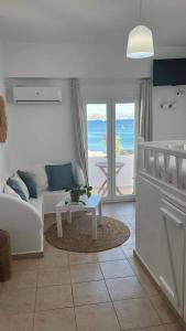 a living room with a white couch and a table at White island rooms in Panteli