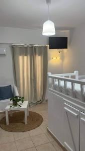 sala de estar con cama, mesa y TV en White island rooms en Panteli