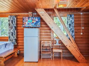 eine Küche mit einem Kühlschrank und eine Treppe in einem Blockhaus in der Unterkunft Holiday Home Mäntylä by Interhome in Soini