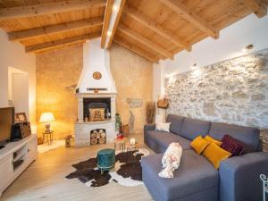 a living room with a blue couch and a stone wall at Holiday Home Villa KIM by Interhome in Brest