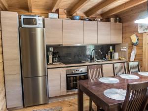 eine Küche mit Tisch und Edelstahlkühlschrank in der Unterkunft Holiday Home Värikatti by Interhome in Vuokatti