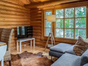 ein Wohnzimmer mit Sofa und Fernseher in der Unterkunft Holiday Home Honkakoli 10 by Interhome in Hattusaari