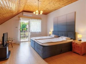 1 dormitorio con 1 cama grande y TV en Holiday Home Violetta 3 by Interhome, en Balatonkenese