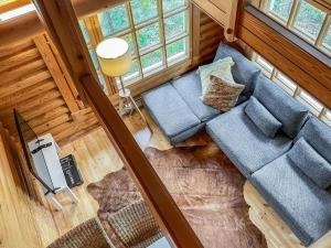 einen Blick über ein Wohnzimmer mit einem blauen Sofa in der Unterkunft Holiday Home Honkakoli 10 by Interhome in Hattusaari + 22 Fotos