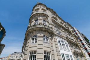un edificio alto con ventanas laterales en SUITE DE LUJO PUERTA DEL SOL+Parking, en Vigo