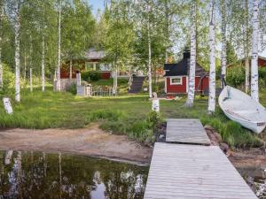 a dock with a boat in front of a house at Holiday Home Villa blanca by Interhome in Ahmovaara