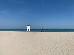 a beach with two chairs and an umbrella on the beach at Apartment Casa delle Palme by Interhome in Marina Romea