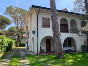a white house with a tree in the yard at Apartment Casa delle Palme by Interhome in Marina Romea