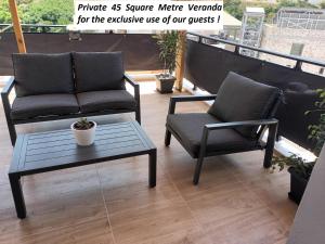 um pátio com 2 cadeiras e uma mesa de centro em Sunset Luxury Suite - Rooftop Apartment in the City Center em Heraclião