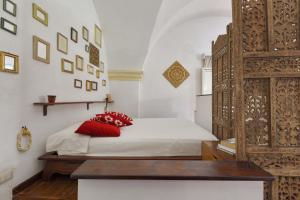 a bedroom with a bed with red pillows on it at Salotto Barocco by BarbarHouse in Lecce