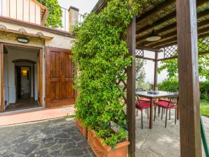 un ingresso a una casa con tavolo e siepe verde di Holiday Home Podere Berrettino-2 by Interhome a Reggello
