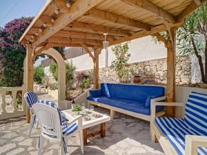 a patio with a blue couch under a wooden pergola at Holiday Home La Repere by Interhome in Benissa