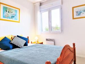 een slaapkamer met een blauw bed en 2 ramen bij Apartment Eskola-2 by Interhome in Bidart