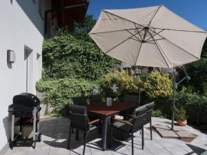 uma mesa e cadeiras com um guarda-sol e um grelhador em Apartment Mittelberghof by Interhome em Hofstetten