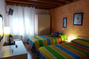 a hotel room with two beds and a window at Hotel El Golobar in Reinosa