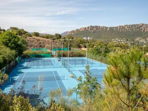 dos pistas de tenis con montañas en el fondo en Studio Village Cap Estérel - Le Village-8 by Interhome, en Agay - Saint Raphael