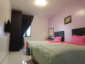 sypialnia z 2 łóżkami i różowymi ścianami w obiekcie HOTEL Benut w mieście Kampong Parit Tengah