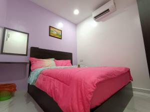 sypialnia z łóżkiem z różowym kocem w obiekcie HOTEL Benut w mieście Kampong Parit Tengah