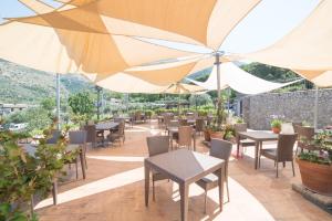 a restaurant with tables and chairs and umbrellas at Il Casale del Golfo in Vico Equense