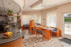 a kitchen and dining room with tables and chairs at Admiral Family Resort in Keszthely
