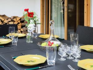 einen Tisch mit gelben Tellern und Gläsern sowie eine Schale Obst in der Unterkunft Apartment Résidence Bristol 4 by Interhome in Villars-sur-Ollon