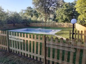 een houten hek met een zwembad in een tuin bij Holiday Home Villa Le Pine by Interhome in Galbino