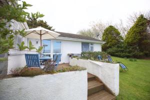 a backyard with a table and chairs and an umbrella at Valley Breeze in Bude