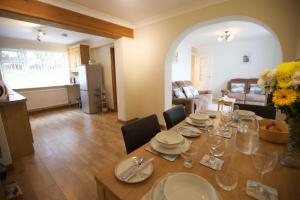 a dining room and living room with a table and chairs at Valley Breeze in Bude