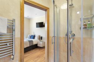 a bathroom with a shower and a bedroom with a bed at West One Studios in Nottingham