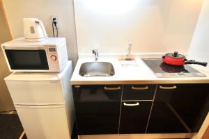 a small kitchen with a microwave and a sink at HIZ HOTEL Kyoto Nijo Castle - Vacation STAY 12567v in Kyoto