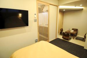 una camera d'albergo con letto e TV a parete di HIZ HOTEL Kyoto Nijo Castle - Vacation STAY 12551v a Kyoto