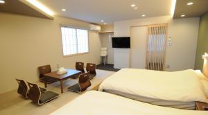 um quarto de hotel com duas camas e uma mesa e cadeiras em HIZ HOTEL Kyoto Nijo Castle - Vacation STAY 12563v em Quioto