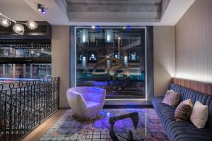 a room with a couch and a table and a window at NH Collection Madrid Gran Vía in Madrid