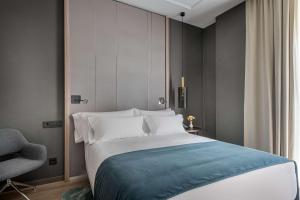 a bedroom with a large bed and a large window at NH Collection Madrid Gran Vía in Madrid