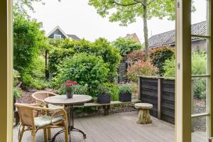 a patio with a table and chairs and a garden at Cottage 'Onder de boompjes' in Oostwoud