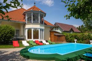 a house with a swimming pool in front of a house at Admiral Family Resort in Keszthely