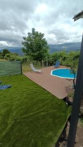 a deck with a pool and two chairs in a yard at Casa com Piscina Privada - Vista Montanhas- Vieira do Minho in Ruivãis