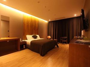 a hotel room with a bed and a desk and a room at Hotel Rich in Goyang