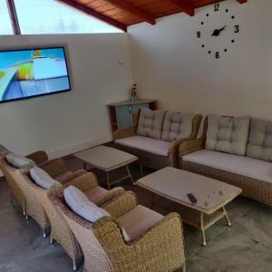 a living room with chairs and couches and a tv at Casa Elena in 2 Mai