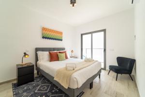 Un dormitorio con una cama grande y una silla. en A GAIVOTA - Walking distance to Monte Clerigo and Amoreira beaches, en Aljezur