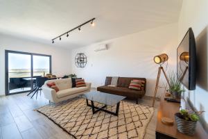 una sala de estar con un sofá y una mesa en A GAIVOTA - Walking distance to Monte Clerigo and Amoreira beaches, en Aljezur