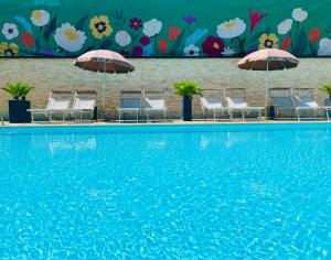 grupa leżaków i parasoli przy basenie w obiekcie Green Park Hotel w mieście Peschiera del Garda